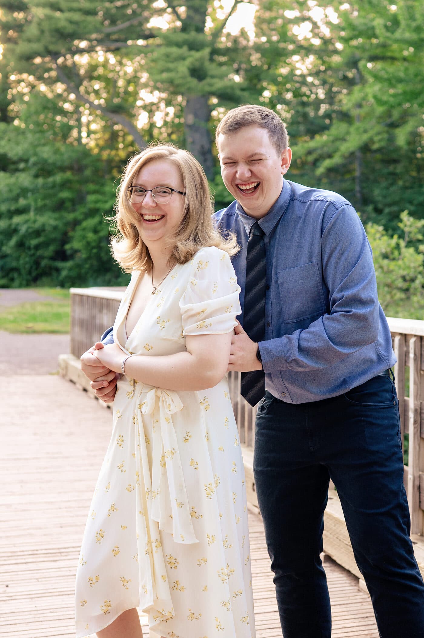 Alexandra and Jérémy laughing together on a wooden bridge